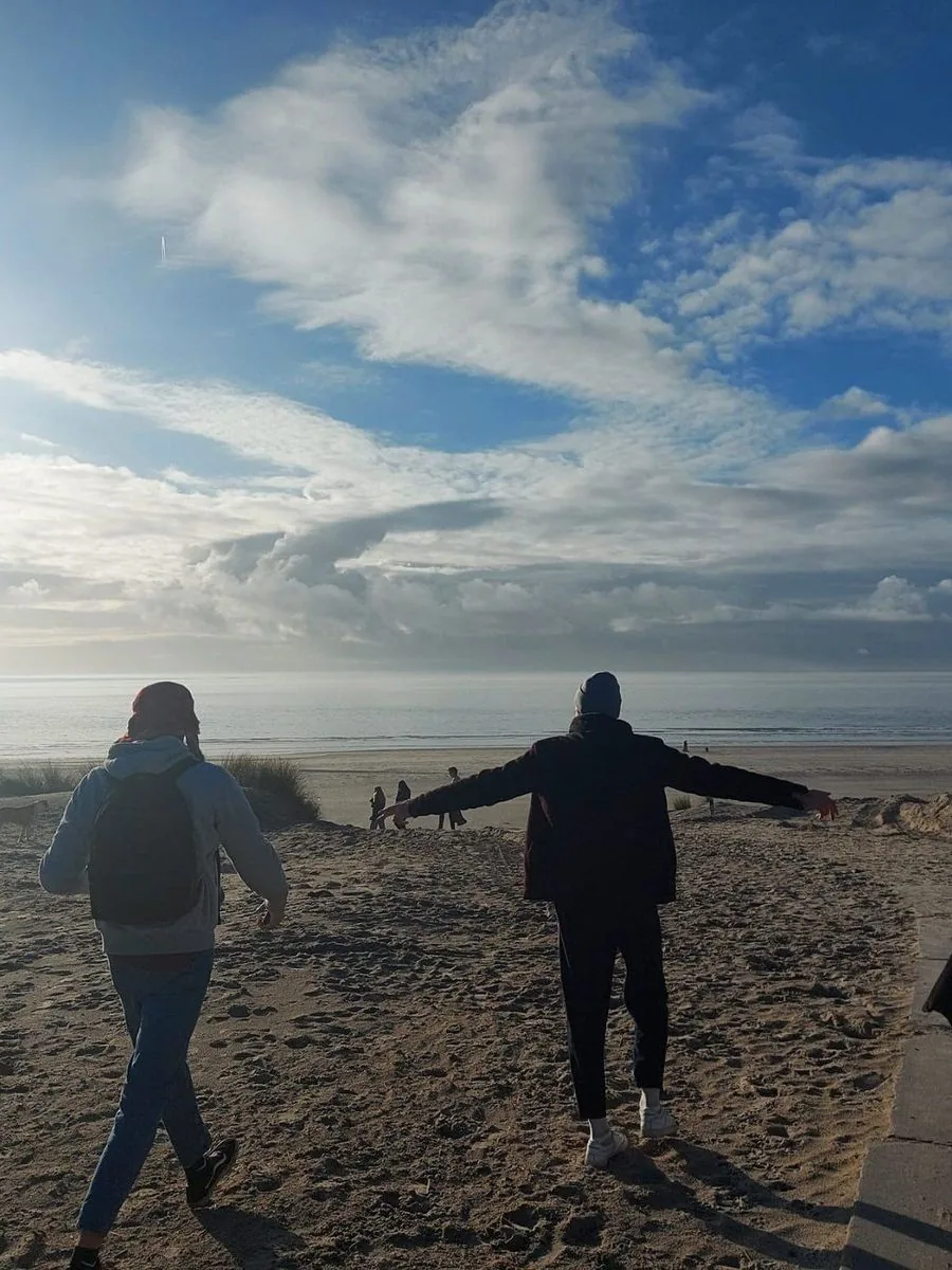Vrienden lopen het strand op bij zonsopgang
